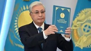 Касым-Жомарт Токаев на фоне флага Казахстана